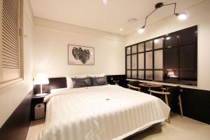 a bedroom with a large white bed and a table at Hotel Able in Changwon