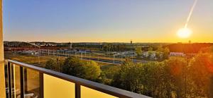グダニスクにあるSłoneczny Apartamentのバルコニーから夕日の鉄道の庭の景色を望めます。