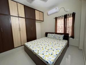 a bedroom with a bed in a room with cabinets at SSN Home Stays in Tirupati Near Alipiri in Tirupati