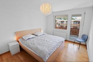 克莱恩 蒙塔纳Appartement central et confortable的一间卧室，里面有一张床、一把椅子和一扇窗户。