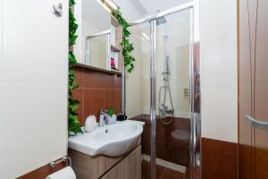 a bathroom with a sink and a shower at Koper House - Cozy & Tropical Oasis steps from the center in Neos Marmaras