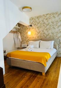 a bedroom with a large bed with a yellow blanket at Gerani Deluxe Houses 2 in Astypalaia Town
