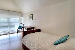 1 dormitorio con cama, mesa y ventana en Appartement Terrasse - Vue Imprenable sur le Golfe, en Larmor-Baden