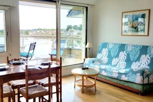 a living room with a table and a couch at Appartement Terrasse - Vue Imprenable sur le Golfe in Larmor-Baden