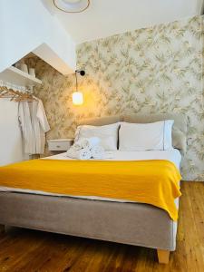 a bedroom with a large bed with a yellow blanket at Gerani Deluxe Houses 2 in Astypalaia