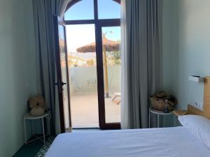 um quarto com uma cama e uma porta para um pátio em TORREMOCHA em Cabo de Palos