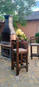 un patio de piedra con un horno al aire libre con una mesa y un banco en Casa Magnolia en Douăzeci şi Trei August