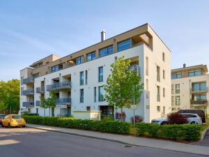 een wit gebouw met auto's ervoor geparkeerd bij DünenResort Binz - Apt. 3.6 in Binz