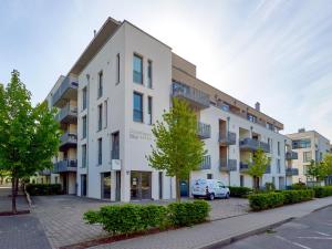 een wit gebouw met een auto ervoor geparkeerd bij DünenResort Binz - Apt. 3.6 in Binz +14 foto's