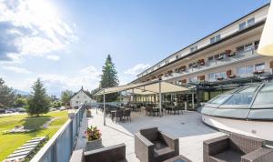 un balcone di un hotel con tavoli e sedie di Hotel-Restaurant Grimmingblick a Bad Mitterndorf