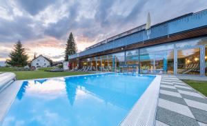 une grande piscine en face d'un bâtiment dans l'établissement Hotel-Restaurant Grimmingblick, à Bad Mitterndorf