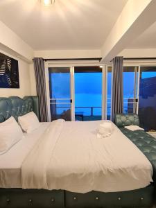 1 dormitorio con cama grande y ventana grande en The Cloud View วิวเหนือเมฆแคมป์ ที่พักวิวสวยเขายายเที่ยง, en Ban Wang Sai