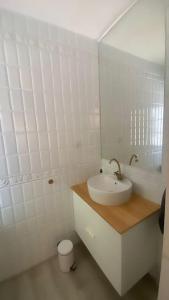 uma casa de banho branca com um lavatório e um WC em La Candela em Cercedilla