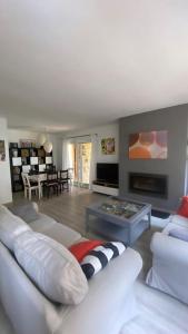 uma sala de estar com um sofá branco e uma mesa em La Candela em Cercedilla