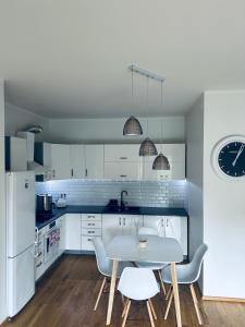 a kitchen with white cabinets and a table and chairs at Isco Apartment in Kuressaare