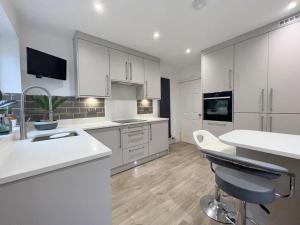 a kitchen with white cabinets and a table and chairs at The Elegance in Chatteris
