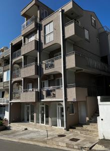 een appartementencomplex met balkons in een straat bij Guest House Mrvaljević in Budva