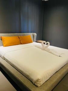a bed with a white blanket with a swan on it at Rabbitel Phuket in Phuket