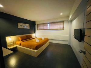 a bedroom with a bed and a window and a television at Rabbitel Phuket in Phuket