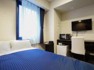 a hotel room with a bed and a television at HOTEL LiVEMAX Tokyo Bakurocho in Tokyo