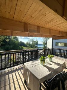 a table and chairs on a deck with a wooden ceiling at Apartment Ormestad in Uddevalla