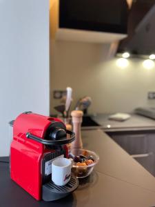 einem roten Toaster auf einer Küchentheke mit einer Schale Obst in der Unterkunft les MAMA Tissia in Lens