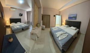 a hotel room with two beds and a chair at Golden days in Afantou