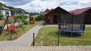 a yard with a playground with a swing at Wantaris 2 - domki letniskowe in Mielenko