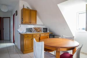 una cucina con tavolo in legno e una cucina con scala di Appartement - Plogoff Pointe du Raz a Plogoff