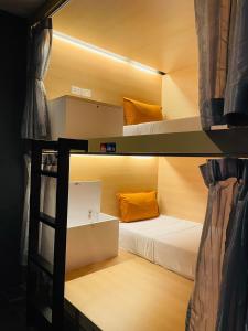 a room with two bunk beds and a ladder at Rabbitel Phuket in Phuket
