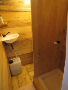 a wooden bathroom with a sink and a toilet at LA BAROUD' ER in Voillecomte
