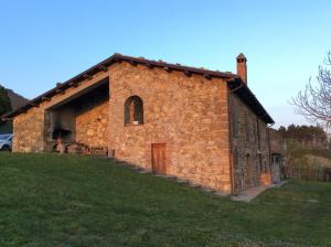 un vieux bâtiment en briques sur une colline herbeuse dans l'établissement Casale Fornello, à Acquapendente