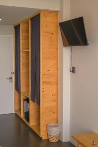 a wooden closet with a television in a room at BananaHill 