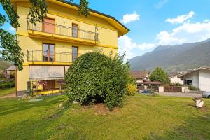 a yellow house with a large bush in front of it at Yellow Apartment in Sarre