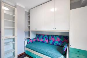 Cette chambre comprend des placards blancs et un canapé vert. dans l'établissement Yellow Apartment, à Sarre