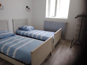 two twin beds in a bedroom with a window at Le Cocon de Mila in Uzer