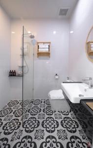 een witte badkamer met een wastafel en een douche bij BananaHill 
