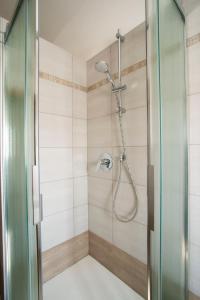 La salle de bains est pourvue d'une douche avec une porte en verre. dans l'établissement Ca' dei Berici, à Tormeno