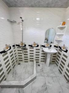 y baño con ducha y lavamanos. en Guesthouse - Family Hotel, en Bagdatʼi