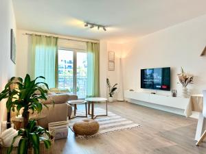 A television and/or entertainment centre at Aguacate Beach Apartamentos Playa Granada