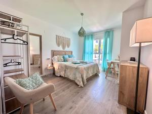 a bedroom with a bed and a chair and a mirror at Aguacate Beach Apartamentos Playa Granada in Motril