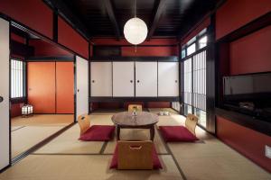comedor con mesa, sillas y paredes rojas en Suo an Machiya House, en Kioto 35 fotos más