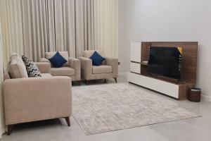 فيلا ساره في المدينة المنورة: غرفة معيشة مع كرسيين وتلفزيون بشاشة مسطحة