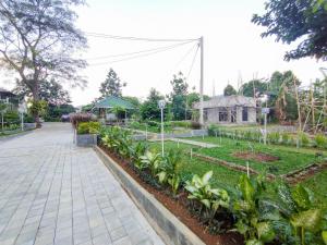 einen Garten mit Gehweg und einigen Pflanzen in der Unterkunft Villa Papatong by M Bogor Mitra RedDoorz in Bogor