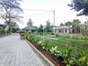 a garden with a walkway and some plants at RedDoorz at Batutulis Bogor Villa Papatong by M in Bogor