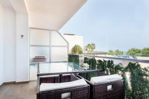 balcón con sillas de mimbre y mesa de cristal en Fantástico apartamento en primerísima línea playa, en La Torre