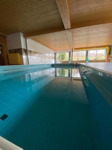a swimming pool with blue water in a building at Ferienwohnung Bergzeit in Oy-Mittelberg