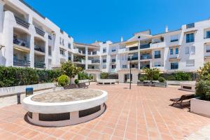 un patio con bancos frente a un edificio en 200m from the beach Apartment San Pedro Marbella, en Marbella