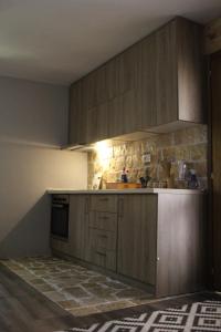 cocina con armarios de madera y encimera en Mountain Village House, en Cetinje
