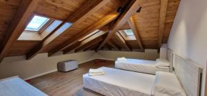 a attic room with two beds and wooden ceilings at Apartaments El Trèvol in Camprodon